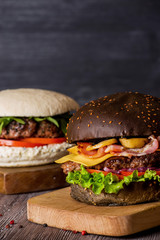 Hamburger with beef and bacon and a white hamburger with french fries on a wooden background.
