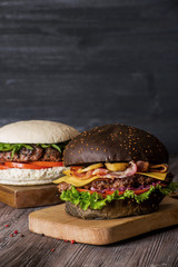 Hamburger with beef and bacon and a white hamburger with french fries on a wooden background.