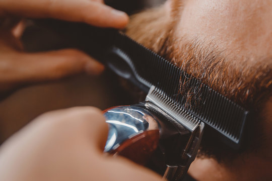Man hipster having barber shave barbershop hair machine.
