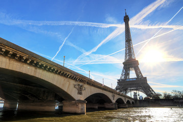 Beautiful backlit Eiffel tower at the Seine river with a dramatic sky in winter