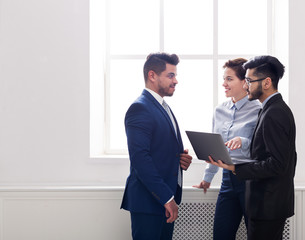 Business colleagues having conversation in office near window