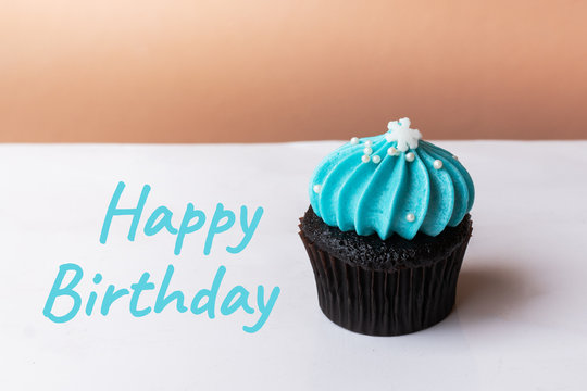 Happy Birthday cute cupcake with small white snow blue cream on white background