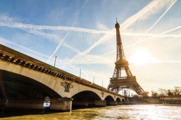 Beautiful backlit Eiffel tower at the Seine river with a dramatic sky in winter