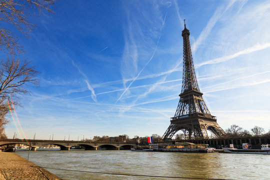 Beautiful Eiffel tower at the Seine river with a dramatic sky in winter