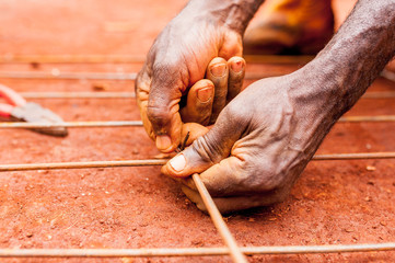 close up of old african man black hands doing manual work on iron