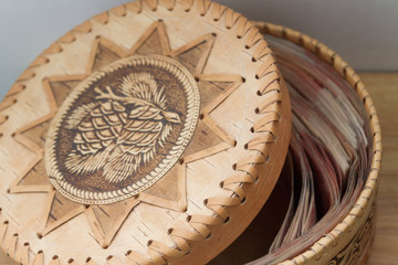 Big Russian money lies in a round wooden wicker box