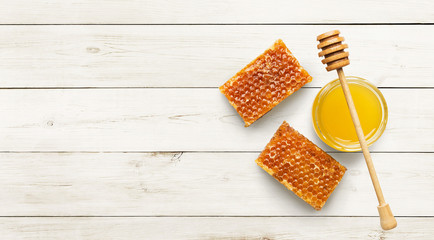 Jar full of fresh honey and honeycombs on white