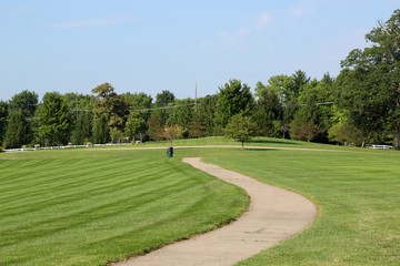 The long winding sidewalk in the park on a sunny day