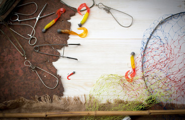 Fishing tackle-fishing spinning rods, hooks, floats and lures on wooden background
