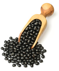 raw black bean in the wooden scoop, isolated on white