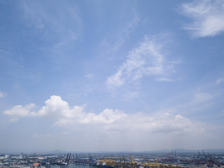 Aerial view of logistics concept floating dry dock servicing cargo ship and commercial vehicles, cars and pickup trucks waiting to be load on to a roll-on/roll-off car carrier ship at Laem Chabang 