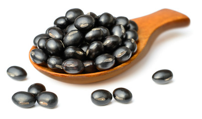 raw black bean in the wooden scoop, isolated on white