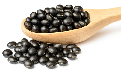 raw black bean in the wooden scoop, isolated on white