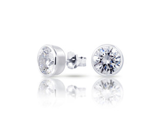 beautiful white diamond stud earrings with reflection on white background