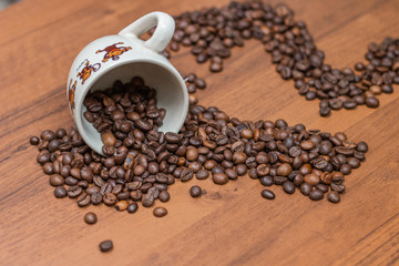 Coffee cup and coffee beans on a wooden background.