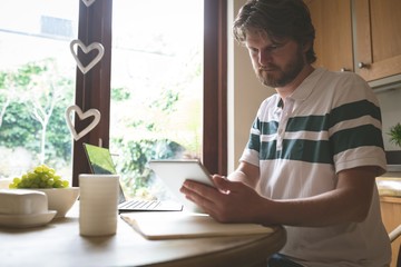 Man using digital tablet on dining table