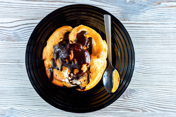 home eclair on a plate on a wooden background 