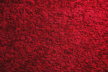 Texture of a dark red carpet. Close-up of gradient light