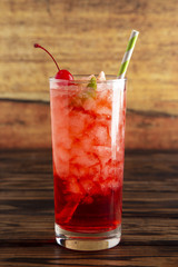 Glass of Cold Refreshing Cherry Limeade on a Wooden Table
