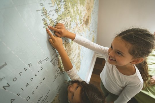 Siblings pointing towards map
