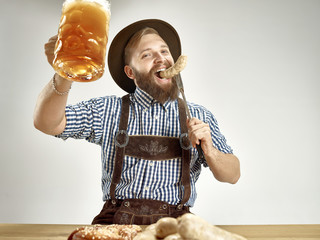 Germany, Bavaria, Upper Bavaria. The young smiling man with beer dressed in traditional Austrian or...