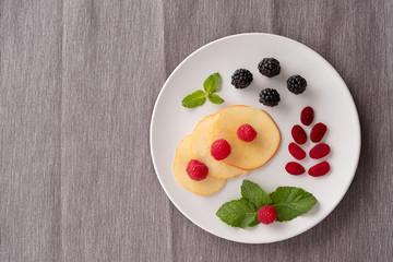 Plate with berries on a gray background. Creative Breakfast ideas for kids