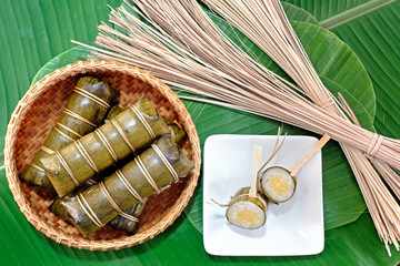 Glutinous rice steamed in banana leaf in bamboo bowl.