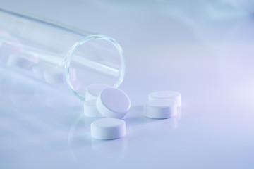 Tabletten mit Glasgefäß im Gegenlicht 