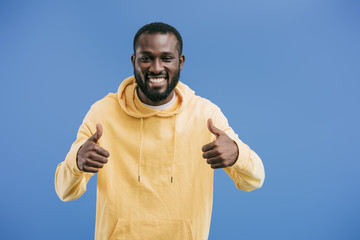 happy young african american man doing thumbs up gestures isolated on blue background