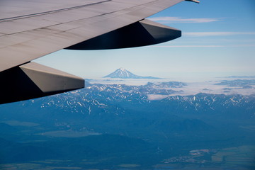 Naklejka na ściany i meble Mountains and volcanoes under the wing of an airplane