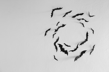 Black paper bats flying wall white