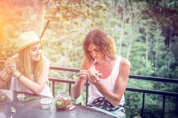 Young couple coffee and tea tasting during sunset in the jungle rainforest of a tropical Bali island.