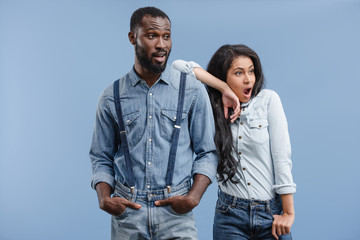 shocked african american couple looking away isolated on blue