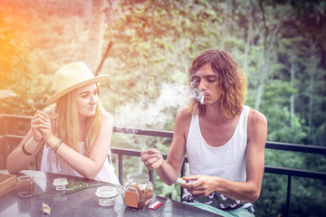 Young couple coffee and tea tasting during sunset in the jungle rainforest of a tropical Bali island.