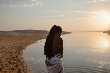 young woman watching the river and sunset