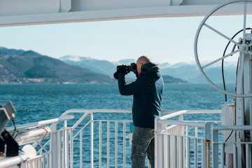 Young caucasian man taking photo of a beautiful landscape on his professional camera. Photographer...