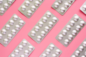 Medicine, pills, drug or tablets in a blister pack on pink background for healthcare and medical concept