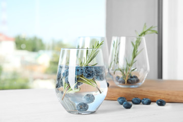 Refreshing blueberry cocktail with rosemary on table - obrazy, fototapety, plakaty