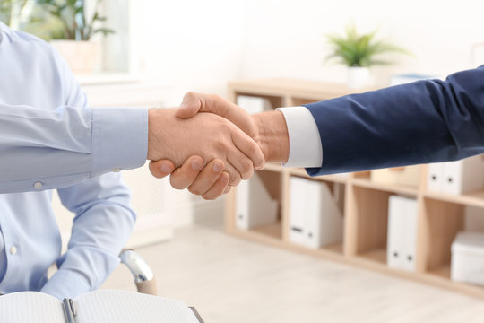 Lawyer handshaking with client in office, closeup