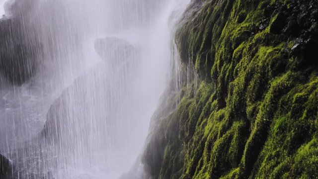 Waterfall cascading over green moss at Kvernufoss in Iceland