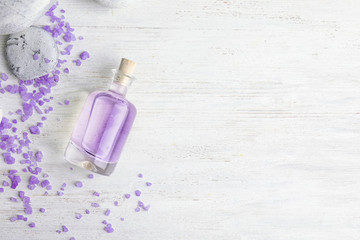 Flat lay composition with natural lavender oil on wooden background. Space for text
