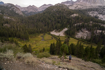 Female backpacker looks at granite valleys at sunset in California's Sierra Nevada along the John Muir Trail © Jeremy Francis
