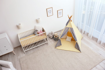 Cozy baby room interior with play tent and toys, above view