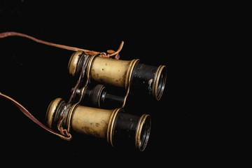 Old binoculars on dark background