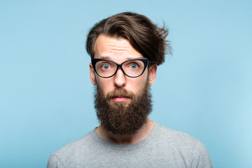 worried nervous alarmed bearded hipster guy wearing cat eye glasses. stylish modern fashionist....