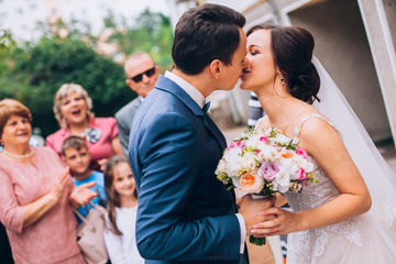 First meet of bride and groom on their wedding. Happy smile bride in veil touches the shoulder of...