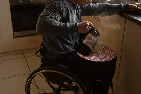 Disabled man preparing coffee in kitchen