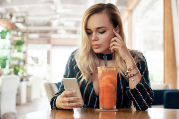 Beautiful woman reading good news on phone