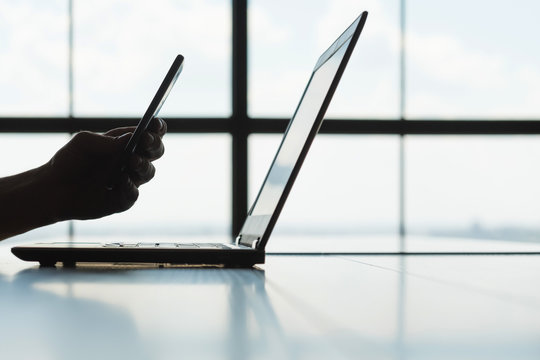 qr codes and safe authorization concept. man scanning laptop screen with mobile phone. technology and personal internet accounts protection.