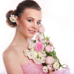 Young beautiful woman with a bouquet of tender spring flowers over white background, ranunculus.